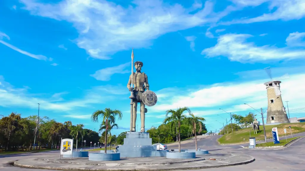 Estátua de Dom Quixote no campus da Universidade Nilton Lins, com o moinho ao fundo